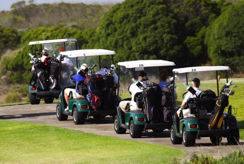 Golf carts and players on a golf course, showcasing Golf Carts Atlanta service.