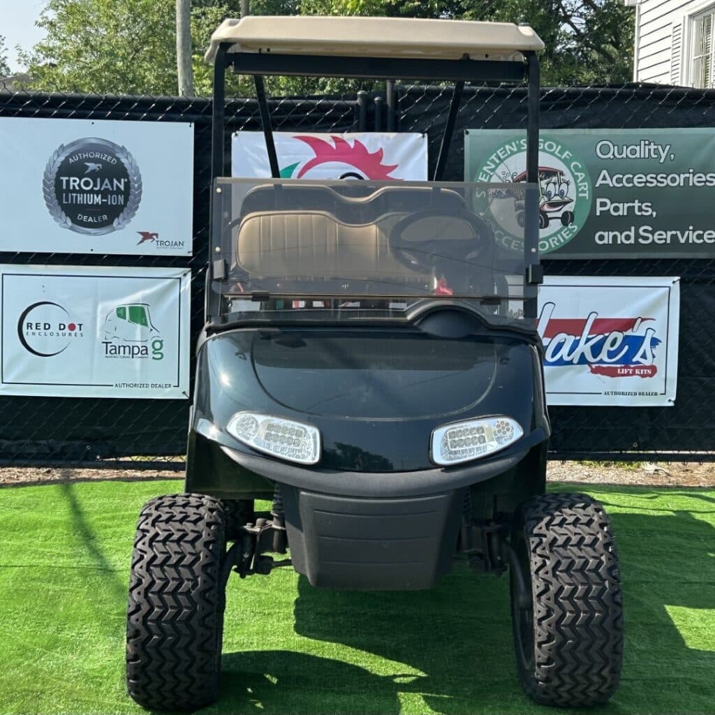 Gray custom golf cart with lithium-ion battery dealer signage and accessories.