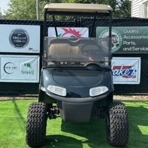 Gray custom golf cart with lithium-ion battery dealer signage and accessories.