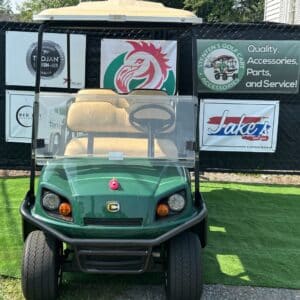 Green Cushman Shuttle 6 golf cart with branded signage and accessories.