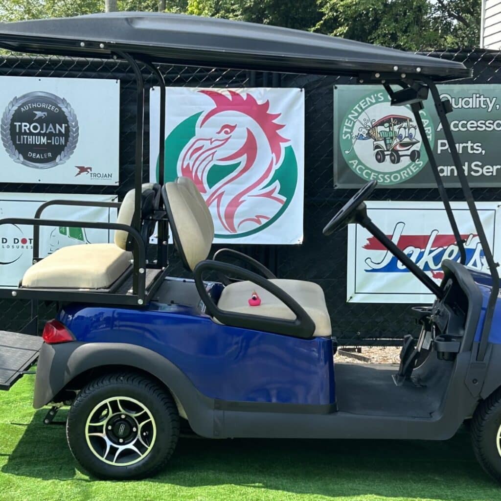 Custom 4-passenger golf cart with premium wheels and accessories, Trojan Lithium-Ion dealer branding.