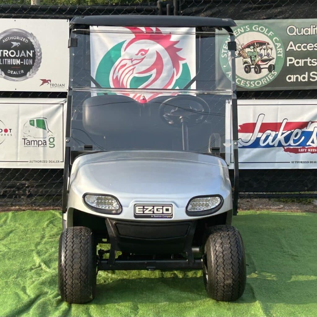 Red and green custom EZGO golf cart with Trojan batteries and Jake's Lift Kits branding.