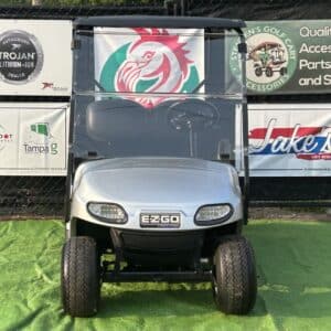 Red and green custom EZGO golf cart with Trojan batteries and Jake's Lift Kits branding.