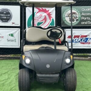 Black Yamaha Drive golf cart with Troyan dealer signage and accessories.